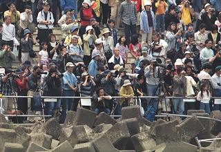 [Many onlookers on the opposite bank]